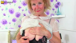 Curvy older woman posing on a couch in a bright room