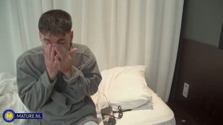 Older couple laughing together on a rumpled bed